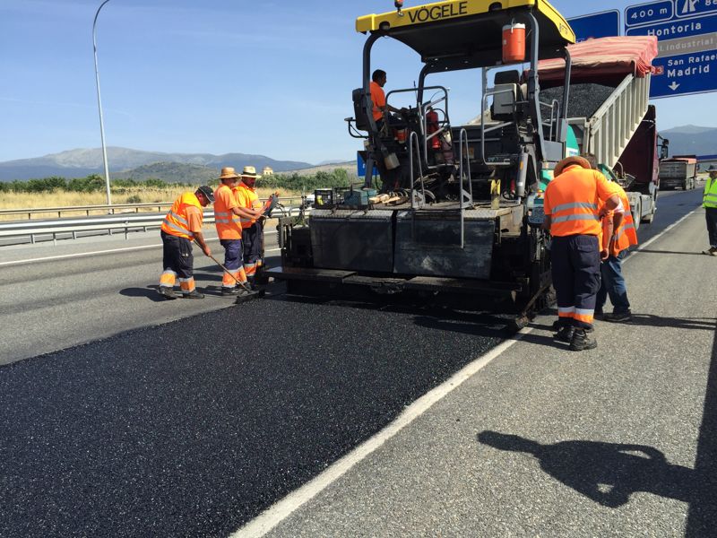 Operarios y extendedora aplicando mezcla reciclada en un carril de la AP-61