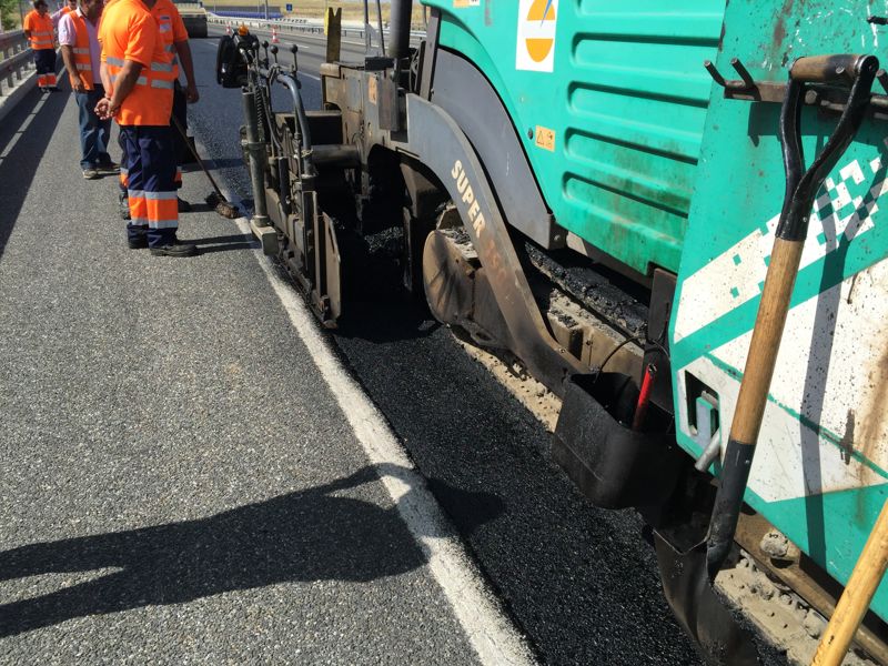 Detalle de la extendedora junto a la marca vial en el tramo de prueba de la AP-61