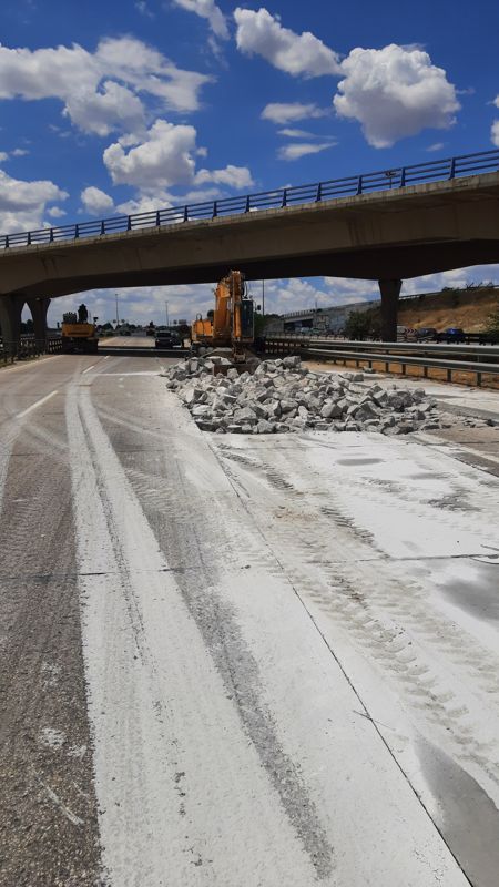Firme fresado bajo un paso superior de la M-50 con maquinaria al fondo
