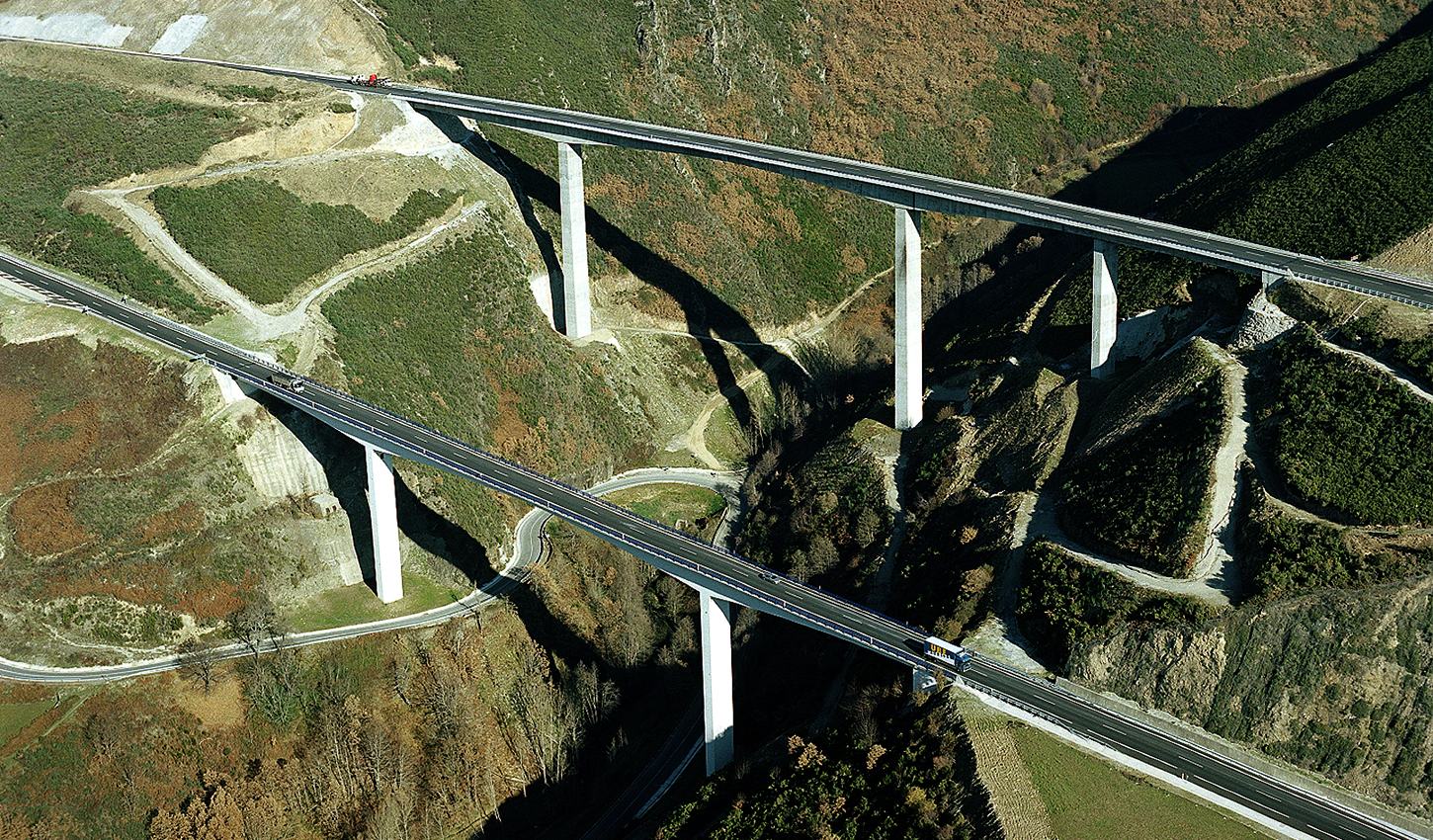Vista aérea de dos viaductos de autovía cruzando un valle de montaña